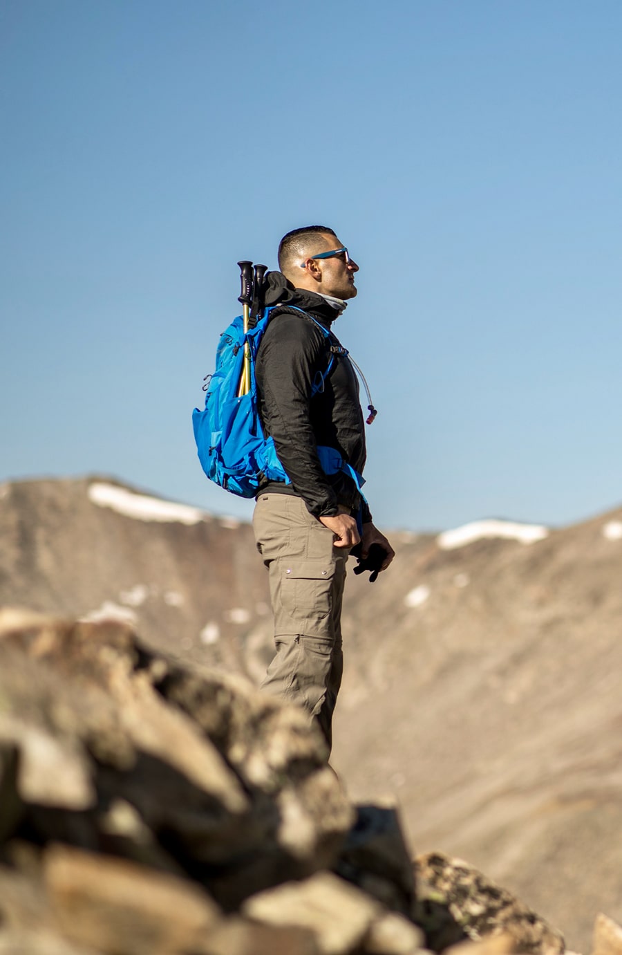 Dr. Cassio Castro, adorned with hiking gear, looking out over a mountain view