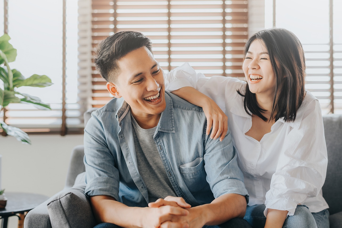 male and woman laughing on a couch in Aurora, CO