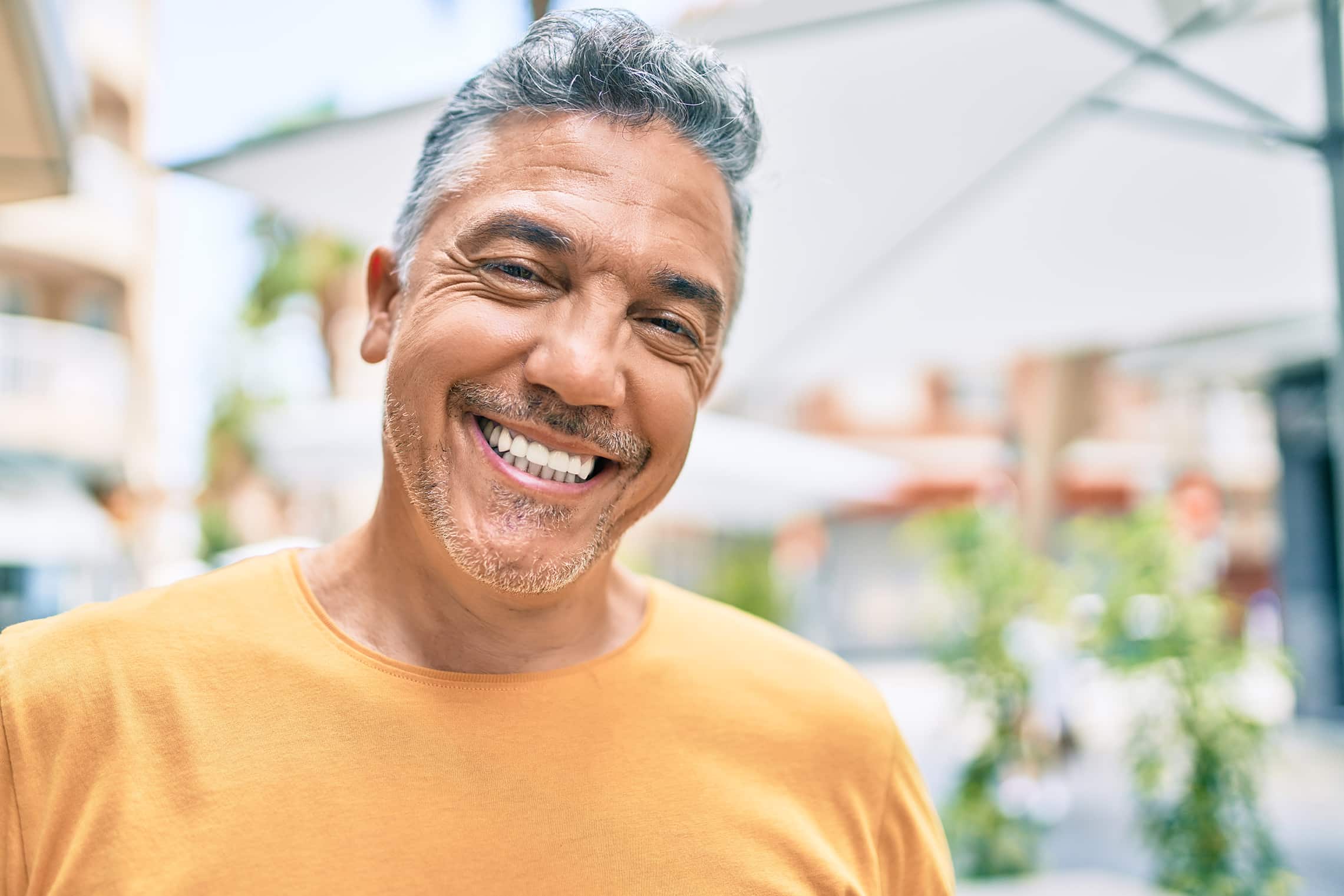 man smiling in aurora colorado after restorative dental appointment at odonto dental