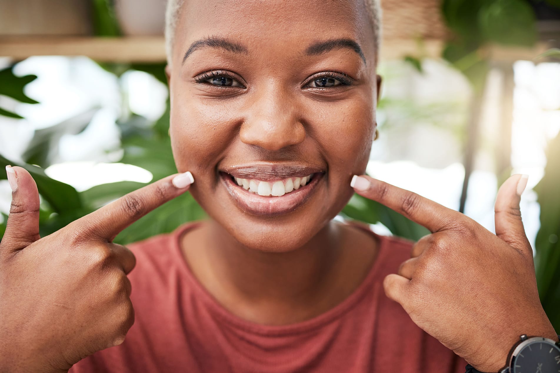 woman pointing to her healthy teeth after dental care at odonto dental in aurora colorado