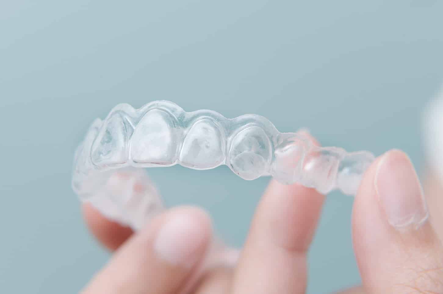 dental patient holding invisalign dental aligners from odonto dental