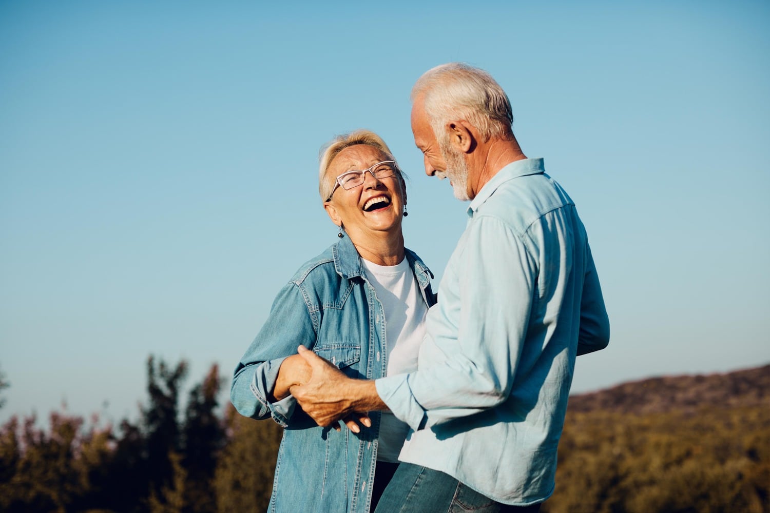 Couple laughs together with healthy smiles after a dental cleaning in Aurora CO